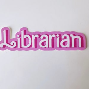 May include: Pink sticker with the word "Librarian" in white letters with a retro font.