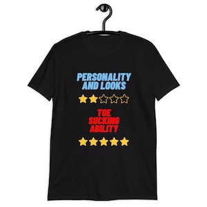 May include: Black t-shirt with the text "PERSONALITY AND LOOKS" with a 3-star rating and "TOE SUCKING ABILITY" with a 5-star rating.
