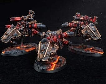 May include: Three miniature sci-fi vehicles with riders, painted in black and metallic bronze with glowing red accents. Each vehicle features angular armor plating and mounted weaponry, positioned on oval bases decorated with a lava-like terrain effect.