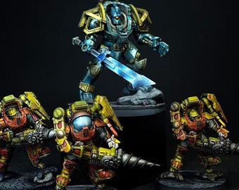 May include: A group of four painted miniature sci-fi figures. One large central figure in blue and gold armor holds a glowing blue sword. Three smaller figures in red and yellow armor stand in front, each equipped with heavy mechanical weaponry.