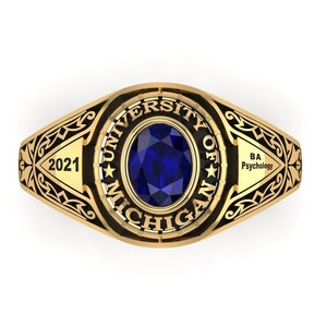 Könnte beinhalten: Goldener Klassenring mit einem blauen Stein und der Inschrift "University of Michigan" und "2021". Der Ring trägt auch die Inschrift "BA Psychology" an der Seite.