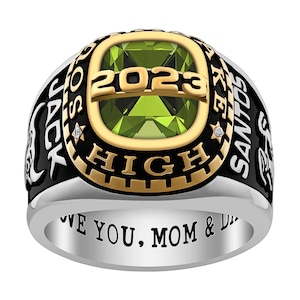 May include: A silver and gold class ring with a green gemstone. The ring has the words "Jack Santos High" and "2023" engraved on it. The inscription on the band reads "Love you, Mom & Dad".
