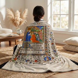 Nativity plush blanket wrapped around a woman's shoulders as she sits on the floor