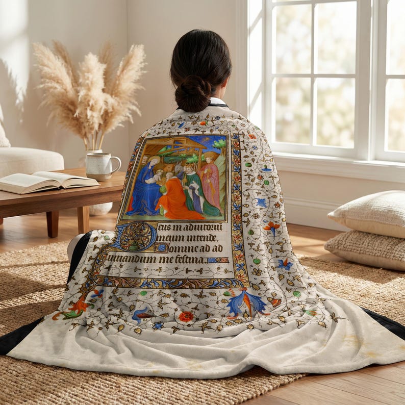 Nativity plush blanket wrapped around a woman's shoulders as she sits on the floor