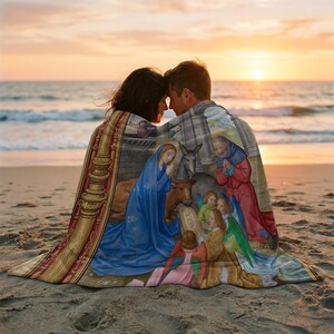 Nativity plush blanket wrapped around a couple on the beach at sunset