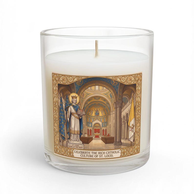 An 11oz glass candle with white wax and an illustrated label featuring a crowned saint holding a cathedral model, flanked by flags, with a ornate church interior backdrop and the text 'Celebrate the Rich Catholic Culture of St. Louis'