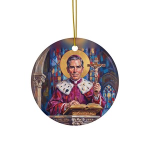 Round ceramic ornament featuring a painted portrait of Blessed Archbishop Fulton J. Sheen in purple vestments with white fur trim, holding a crucifix at a pulpit, with a golden halo and stained glass background, hung on a gold cord