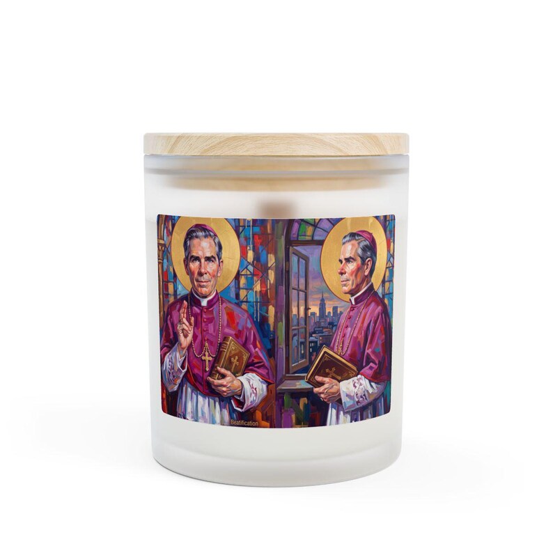 Frosted glass 11 oz candle with a wooden lid, featuring a printed label showing two painted portrait views of Blessed Archbishop Fulton J. Sheen in magenta vestments with a gold halo, holding a book and rosary