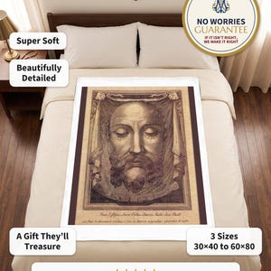 Holy Face plush blanket spread flat on a neatly made bed under a wooden crucifix, a rosary on the nightstand