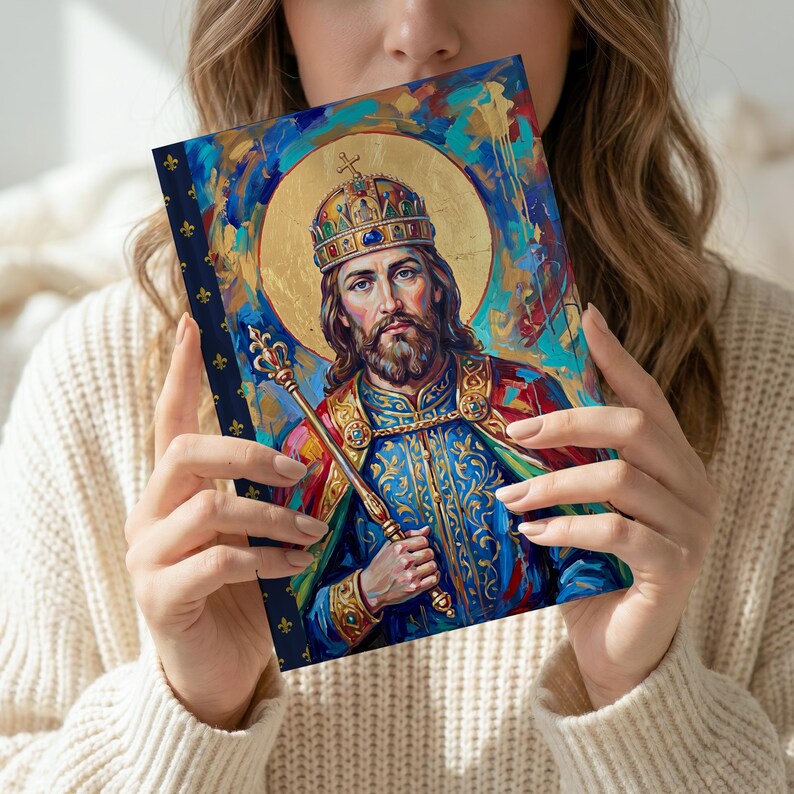 Styled photograph of St. Stephen of Hungary lined journal, with the prayer typeset on the back cover, navy and gold fleur-de-lis spine, model close-up, tilted