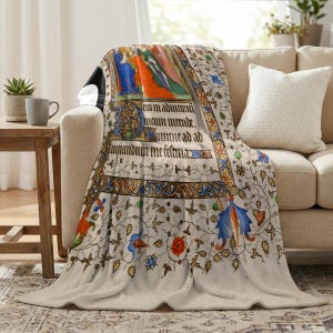 Nativity plush blanket draped over the arm of a cream sofa