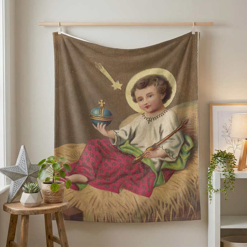 Christmas plush blanket hung on a wall from a wooden rod above a small plant stand