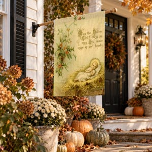 Nativity garden flag in the large size, hung from a wall pole beside a front door with an autumn wreath