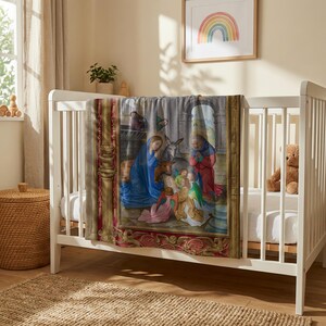 Nativity plush blanket hung over the rail of a white crib with a teddy bear inside