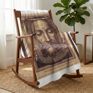 Holy Face plush blanket draped over a wooden rocking chair