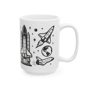 May include: White ceramic mug with a black and white illustration of space shuttles, a planet, and stars.