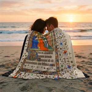 Nativity plush blanket wrapped around a couple on the beach at sunset
