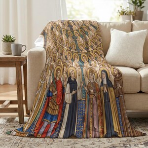 All Saints plush blanket draped over the arm of a cream sofa