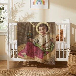 Christmas plush blanket draped over the side of a white crib in a nursery