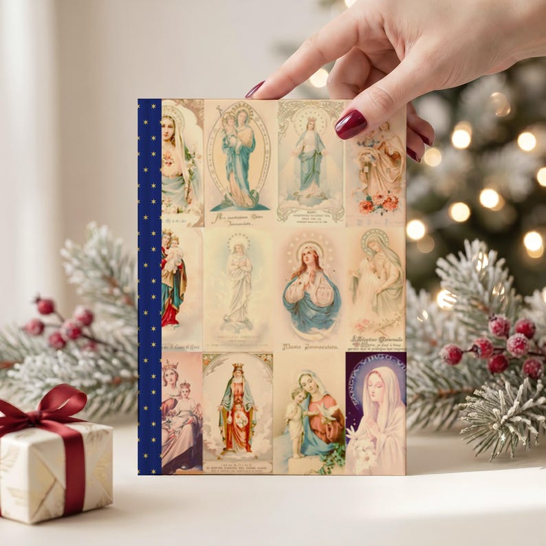 Photograph of Queenship of Mary lined journal, with the prayer typeset on the back cover, navy and gold star spine, christmas interior