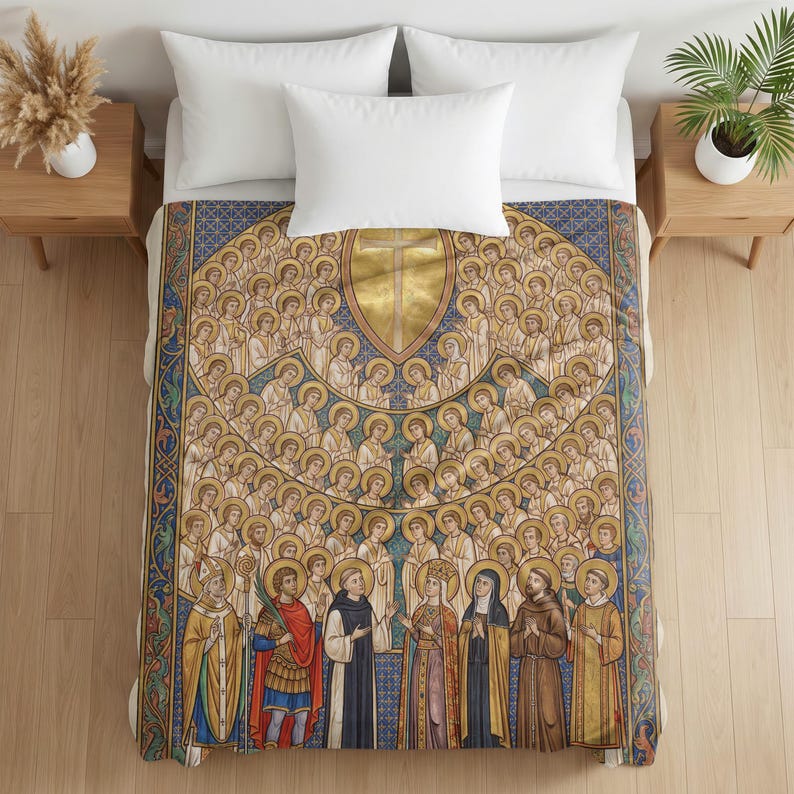 Plush blanket draped over a bed with white pillows, featuring religious iconography of All Saints with figures in gold halos arranged in rows against a blue and gold patterned background, displayed on wooden nightstands with potted plants