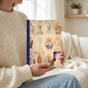 The Queenship of Mary lined journal, with the prayer typeset on the back cover, navy and gold star spine, model in living room