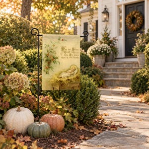 Nativity garden flag on a garden stand among autumn hydrangeas and pumpkins by a front walk