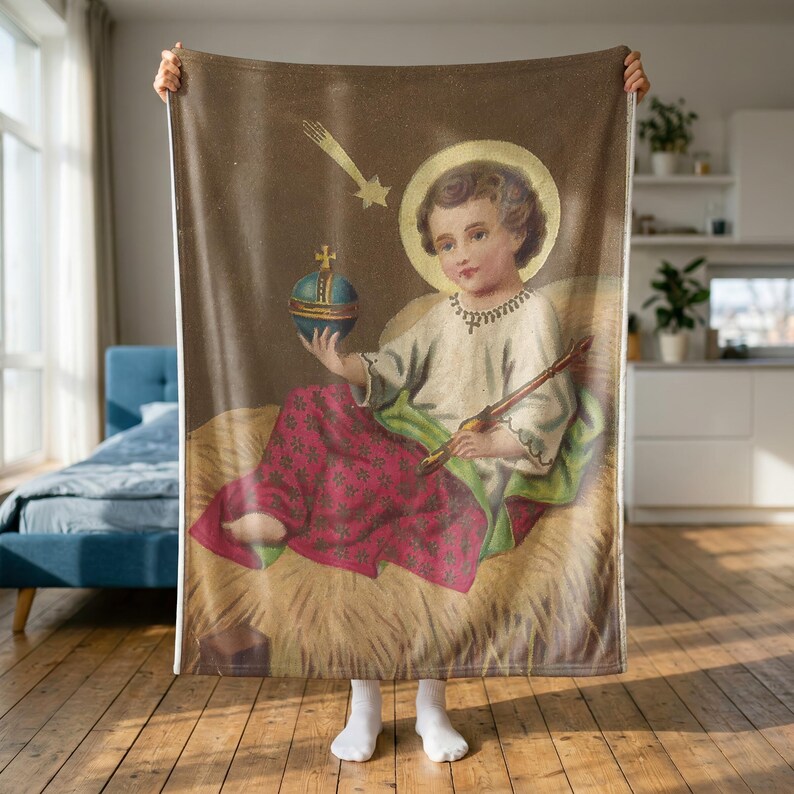 Christmas plush blanket held up to show its full size in a bright room