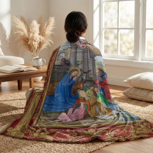Nativity plush blanket wrapped around a woman's shoulders as she sits on the floor