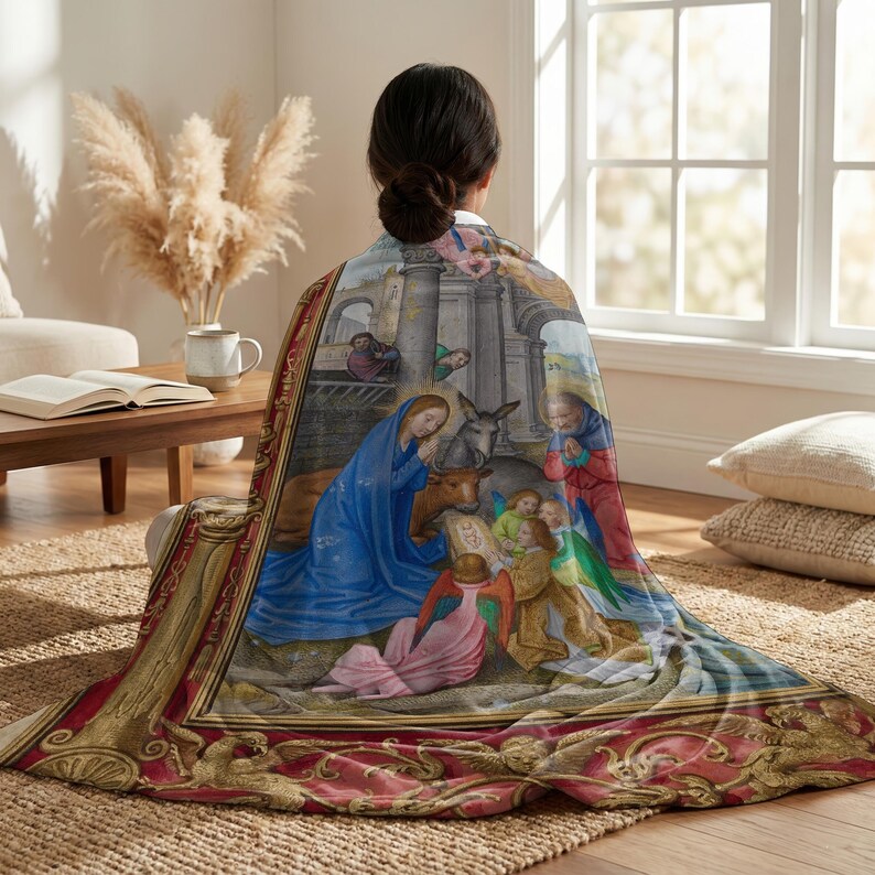 Nativity plush blanket wrapped around a woman's shoulders as she sits on the floor