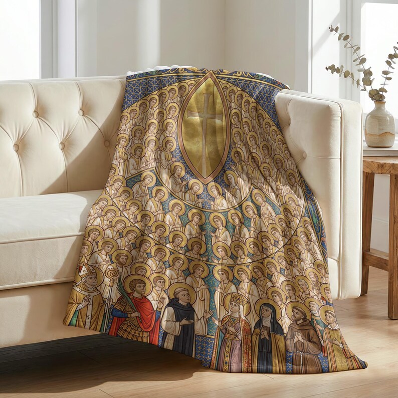 All Saints plush blanket draped over the arm of a tufted cream sofa
