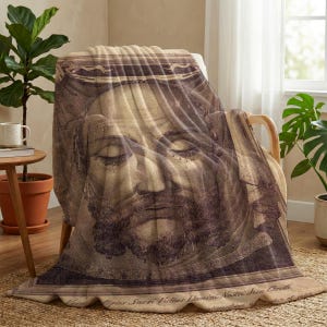 Holy Face plush blanket draped over a chair beside a window