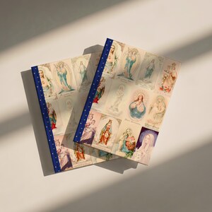 Another view of Queenship of Mary lined journal, with the prayer typeset on the back cover, navy and gold star spine, two journals