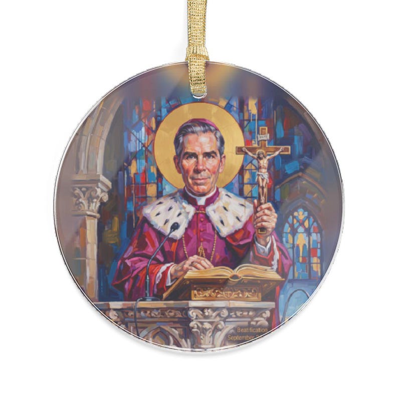 Round clear acrylic ornament hung with a gold ribbon, printed with an illustrated portrait of Blessed Archbishop Fulton J. Sheen in purple and white vestments, holding a crucifix at a pulpit, with a golden halo and stained glass windows behind him
