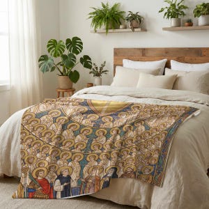 All Saints plush blanket spread across the foot of a bed with a wooden headboard