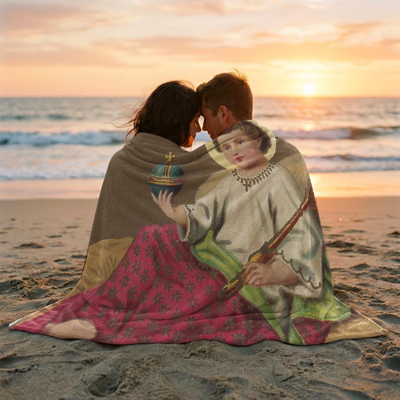 Christmas plush blanket wrapped around a couple on the beach at sunset