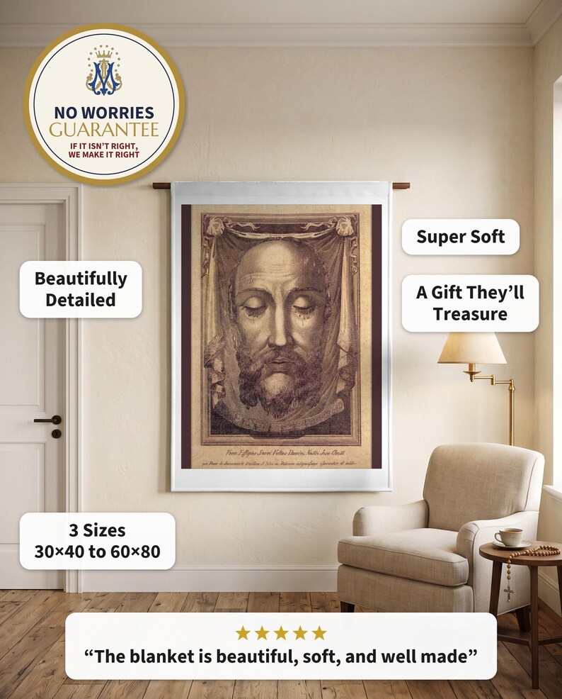 Holy Face plush blanket hung flat on a warm plaster wall from a wooden rod beside an upholstered reading armchair and a lamp
