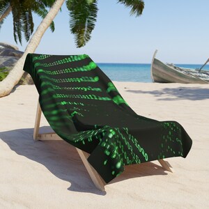 May include: A black beach chair with a green and black beach towel featuring a binary code pattern. The chair is on a sandy beach with palm trees and a wooden boat in the background.