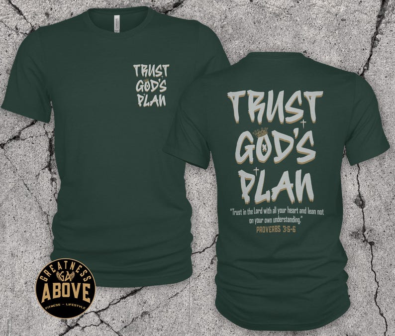 May include: A dark green short-sleeve t-shirt featuring the text "TRUST GOD'S PLAN" in white and tan on the front left chest and a larger version on the back, which also includes the text "Trust in the Lord with all your heart and lean not on your own understanding. PROVERBS 3:5-6."
