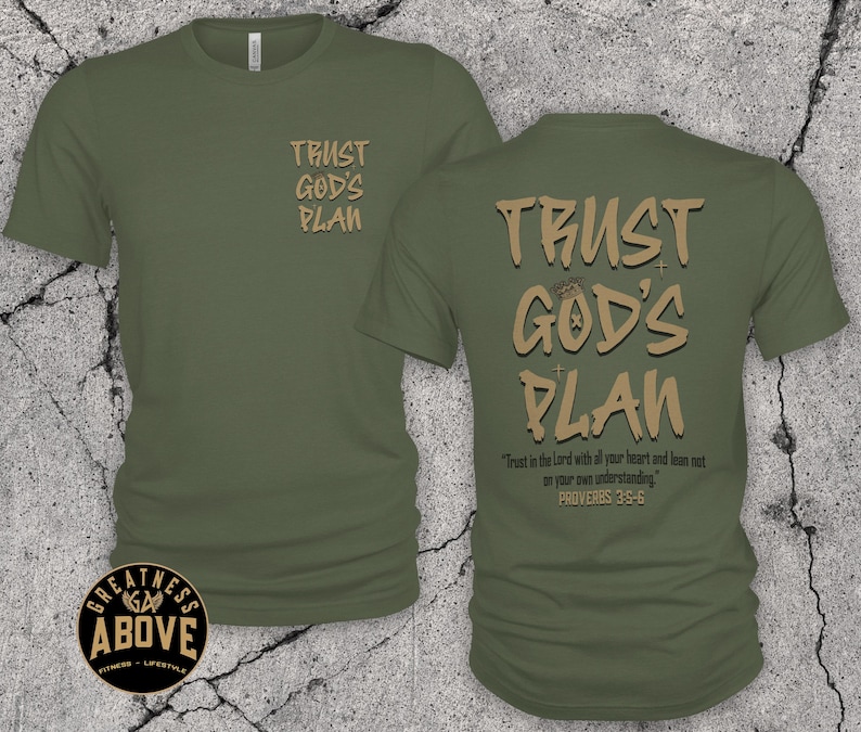 May include: An olive green short-sleeve t-shirt featuring the text "TRUST GOD'S PLAN" in tan on the front left chest. The back displays the same text in a larger font, along with the verse "Trust in the Lord with all your heart and lean not on your own understanding. PROVERBS 3:5-6."