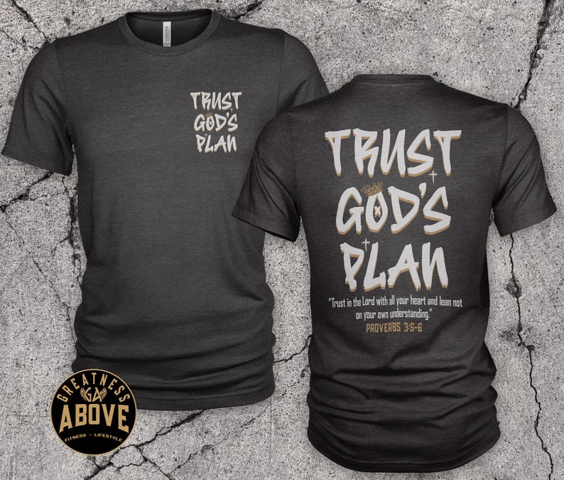 May include: A charcoal gray short-sleeve t-shirt featuring the text TRUST GOD'S PLAN on the front left chest and a larger version on the back with the verse Trust in the Lord with all your heart and lean not on your own understanding. PROVERBS 3:5-6.