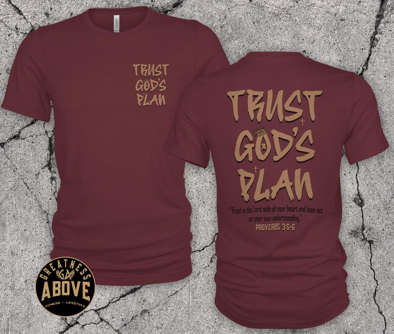 May include: A maroon short-sleeved t-shirt featuring the text TRUST GOD'S PLAN in tan on the left chest and a larger version on the back with the additional text Trust in the Lord with all your heart and lean not on your own understanding. PROVERBS 3:5-6.