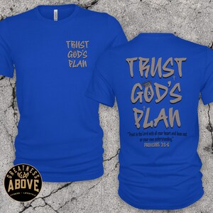 May include: A royal blue short-sleeve t-shirt featuring the text TRUST GOD'S PLAN in grey on the front left chest and in a larger size on the back. The back also includes the text Trust in the Lord with all your heart and lean not on your own understanding. PROVERBS 3:5-6.