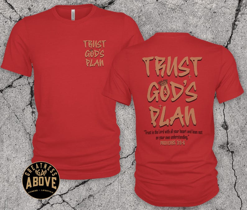 May include: A red short-sleeved t-shirt featuring the text TRUST GOD'S PLAN in tan on the front left chest. The back displays the same text in a larger font, along with the scripture Trust in the Lord with all your heart and lean not on your own understanding. PROVERBS 3:5-6.