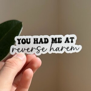 May include: White sticker with black text that reads "You had me at reverse harem".