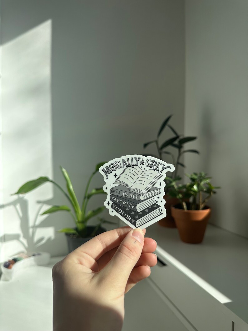 May include: A sticker with a stack of books and the text "Morally Grey is my favorite color".