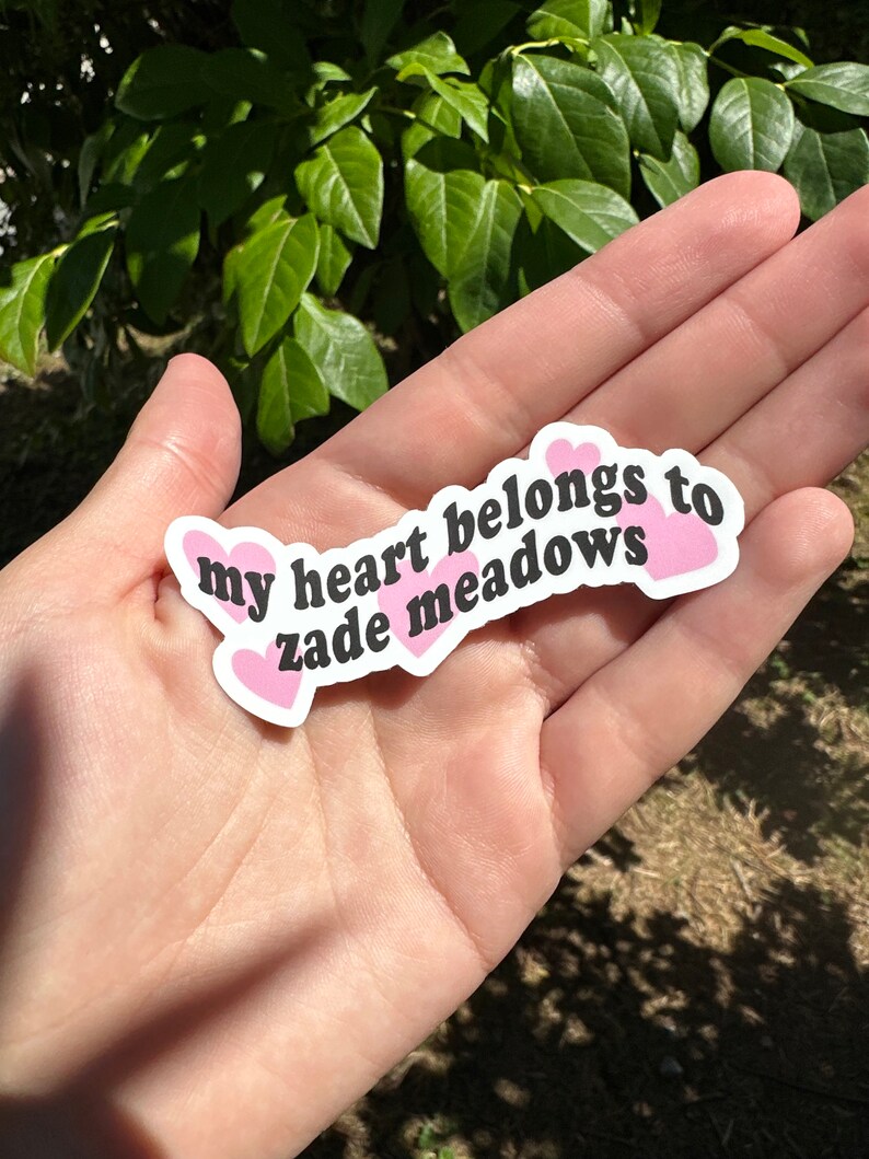 以下が含まれることがあります： ピンクのハートと「my heart belongs to zadie meadows」というテキストが書かれた白いステッカーです。