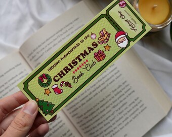May include: A green and white Christmas Book Club bookmark with festive illustrations, including a Christmas tree, Santa, and a rocking horse. The bookmark reads "lifetime membership to the CHRISTMAS Book Club."