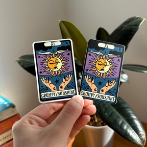 May include: Two tarot card stickers with a sun and moon design. The cards are white with black borders and feature the text "XI GRUMPY/SUNSHINE".