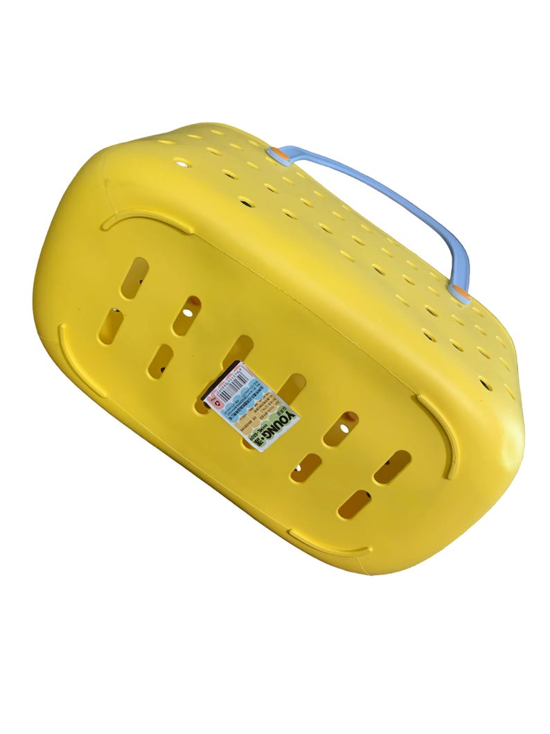 May include: A yellow plastic pet carrier with a blue handle. The carrier has multiple ventilation holes and a label that reads "YOUNG-3". The carrier is designed for transporting small animals.